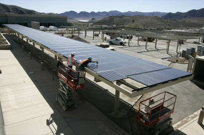 Jimmy Massimino, left, and Serge Bergen of Bombard Electric install solar panels this month at Alfred Merrit Smith Water Treatment Plant at Lake Mead. More than 3,000 jobs such as this would be created in Nevada if the federal government were to require utilities to buy 20 percent of their power from renewable sources, according to a report.
