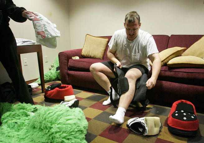 Dave Romleski removes his knee brace after performing in a $12,500 bull suit as The Duke, during a game last year. He says he loses about 10 pounds a game and sweats through a dozen T-shirts.
