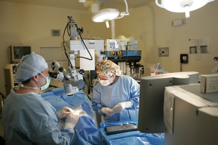 Dr. Thomas Kelly, left, and surgical technician Cristina Reyes operate on Joseph's left eye at the Seven Hills Surgery Center in December.