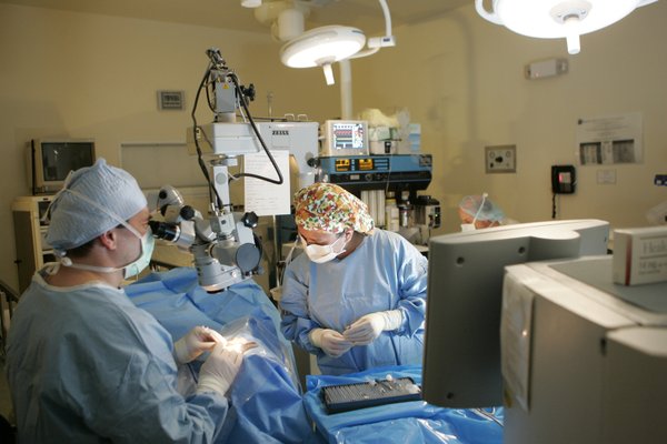 Dr. Thomas Kelly, left, and surgical technician Cristina Reyes operate ...