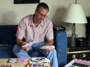Frank Warren thumbs through submissions for his art project, PostSecret, at his home in Germantown, Mass.