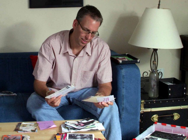 Frank Warren thumbs through submissions for his art project, PostSecret, at his home in Germantown, Mass.