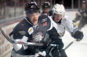 Adam Cracknell, left, of the Las Vegas Wranglers battles for the puck Saturday against Bryan Nathe of the Phoenix RoadRunners during a recent game at the Orleans Arena.