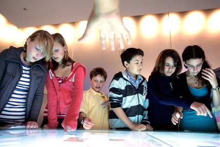 Children play an interactive game inside the Newseum's Ethics Center during the opening day.