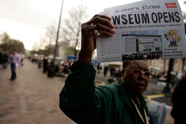 Newseum visitor representative Melvina Johnson hands out opening day announcements ...