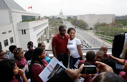 Kevan Kentish, left, and Keisha Dunston, both teachers at Howard Road Academy in Washington D.C. get their photo taken on the Hank Greenspun Terrace on Pennslyvania Avenue during opening day festivities at the Newseum.