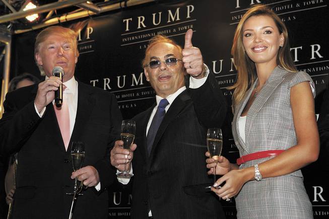 Donald Trump, left, developer Phil Ruffin and his wife, Oleksandra Ruffin, celebrate with a toast during the ribbon-cutting ceremony for the Trump International Hotel and Tower. 