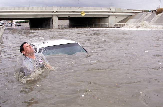 Tony Glenn from Quality Towing comes up for air after attaching a towing cable to a car that was caught in floodwaters at the Charleston underpass on October 27, 2000. While Las Vegas doesn't get much rain, when the skies open up flash floods are always a possibility.