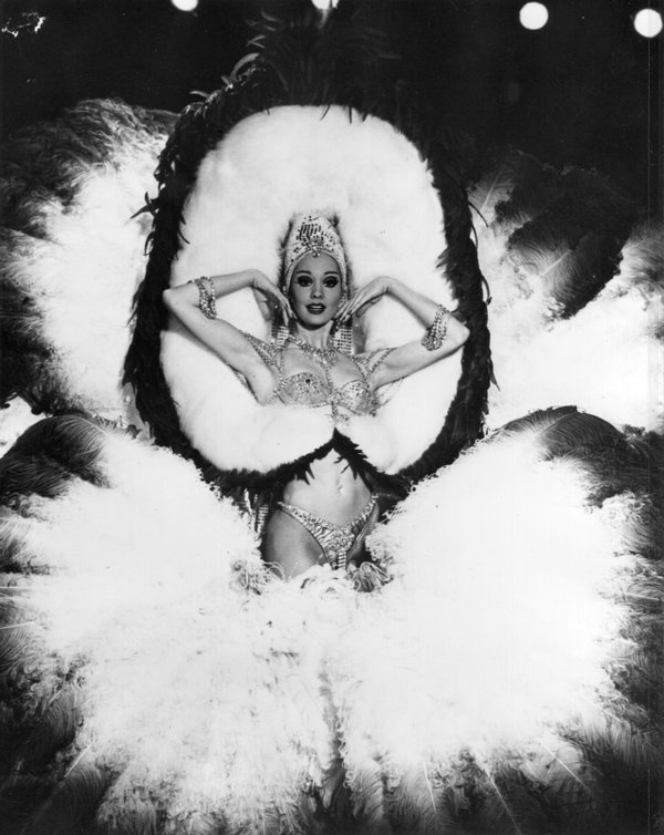 A Folies Bergere performer poses for the camera during a ...