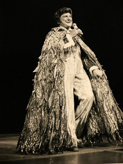 Liberace dons one of his many extravagent outfits, while singing on stage during a performance at the Las Vegas Hilton on May 3, 1979.