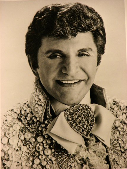 Liberace smiles for a promotional photo, living up to his reputation as 