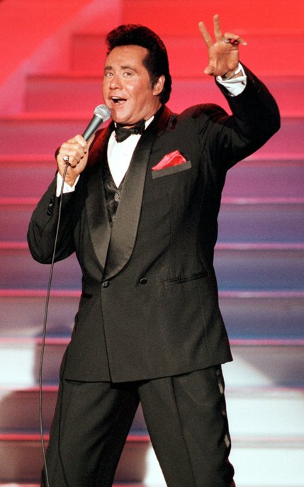 Entertainer Wayne Newton throws up a peace sign during a performance at the Hollywood Theatre in the MGM Grand hotel-casino.