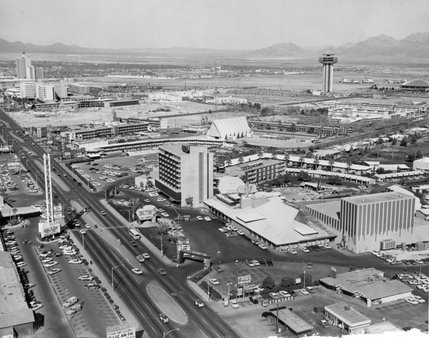 A 1964 aerial view of the Las Vegas Strip shows the Desert Inn and New Frontier hotels. The control tower-like Landmark hotel wouldn't open until 1968 after it was purchased by Howard Hughes.  Hughes himself would come to live in the penthouse suite of the Desert Inn in 1966, where he would negotiate purchases that would change the face of Las Vegas.