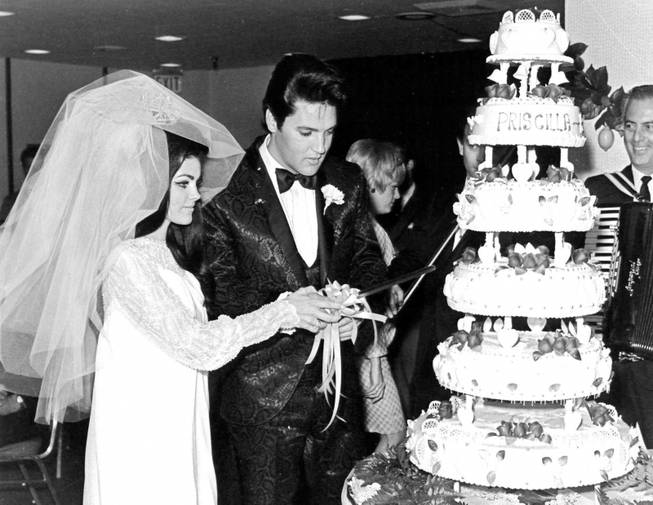 Elvis and Priscilla Presley cut their wedding cake after exchanging vows in the Aladdin Hotel-Casino on May 1, 1967.