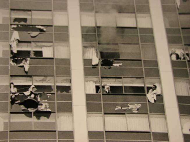 Guests of the MGM break the windows of their rooms in an effort to get fresh air, Nov. 21, 1980. MGM guests employed a range of techniques to avoid smoke inhalation. Some put towels underneath doors to block out the smoke, while others wrapped wet towels around their faces. 
