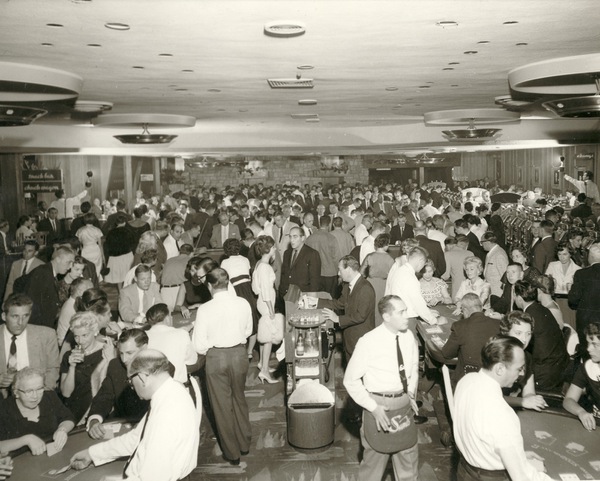 Guests crowd the table games pit at the Sands Hotel's ...
