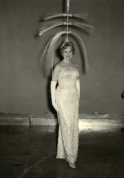 A burlesque dancer showcases an extravagant headpiece as part of a 