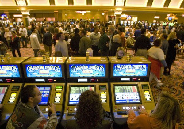 A group of gamblers use the slot machines during the ...