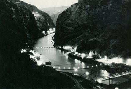 Lights illuminate Black Canyon at the Boulder Dam construction site. The immense project demands attention from workers day and night. Many of them worked eight-hour shifts, seven days a week with no holidays. Work continued around the clock during construction.