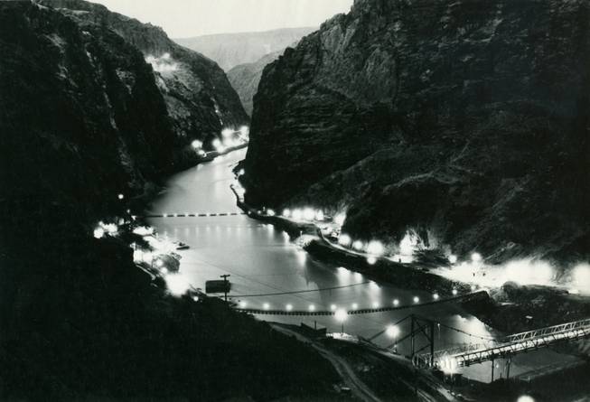 Lights illuminate Black Canyon at the Boulder Dam construction site. ...
