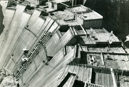 Workers are shown pouring concrete at Hoover Dam. Refrigerated water from the Colorado River cools the tubes within the concrete to help remove heat generated by the solidifying process. Only one worker has officially been buried at the dam. He falls into the river and is dragged to the bottom. His body is later found stuck inside one of the temporary structures called cofferdams.