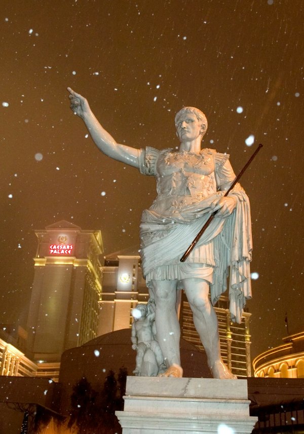 Snow falls around a statue of Julius Caesar in front ...