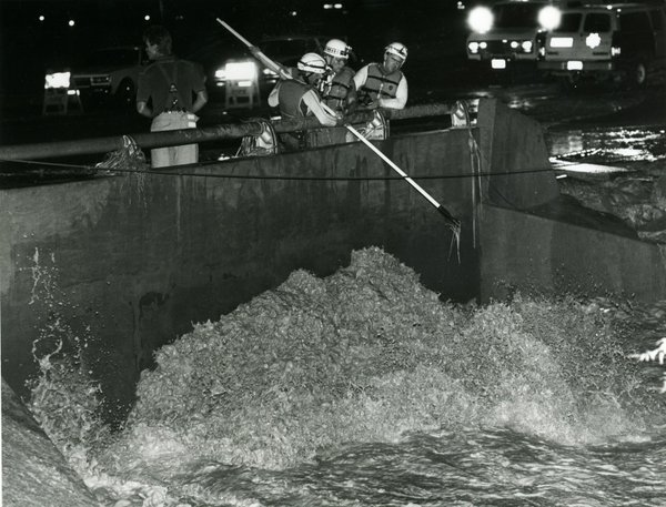July 17, 1990. Search and Rescue officers prod into flood ...