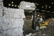 Forklift operator Godiell Harris arranges bales of high-density polyethylene plastic at the Republic Services recycling facility.