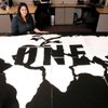 Heather Brown, president of the ONE campaign at UNLV, looks over artwork created by students during a 