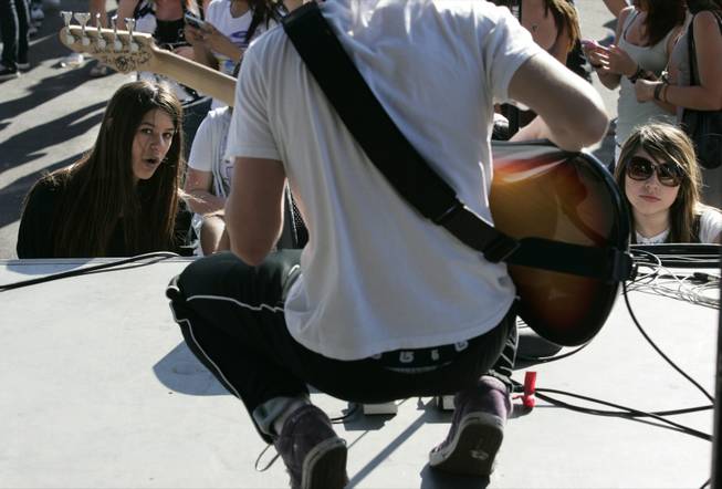 Fans watch as bassist Adam Knaff -- known professionally as Bomb - tunes up at the Extreme Thing festival in Desert Breeze Park. He's the brother of lead singer Brandon Knaff, who taught him to play after a "random guy" Brandon was starting a band with didn't work out.
