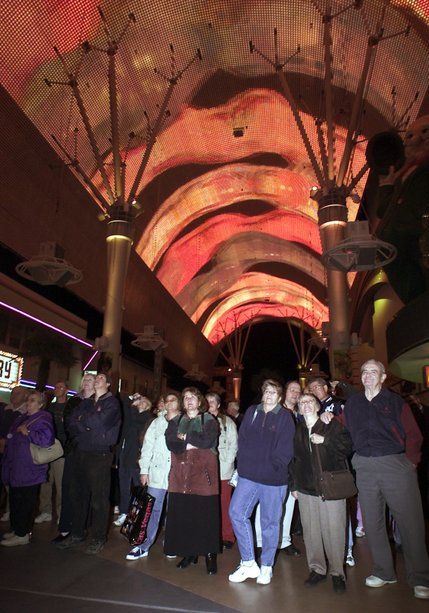 People react as they watch the first showing of “Aria,” a light and sound show created by artist Jennifer Steinkamp and composer Jimmy Johnson for the Fremont Street Experience. The show was part of a ceremony that included the dedication of five refurbished neon signs for the Neon Museum.