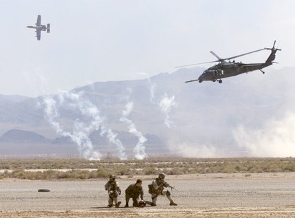 Airmen simulate rescuing a downed pilot as an A-10 Thunderbolt jet aircraft provides close air support for an HH-60G Pavehawk helicopter during a Capstone firepower demonstration at the Nevada Test and Training Range Friday, July 19, 2002. About 2,000 spectators, along with some top officials from the Air Force, were on hand to watch personnel in warplanes and helicopters demonstrate their bombing and rescue operation skills.