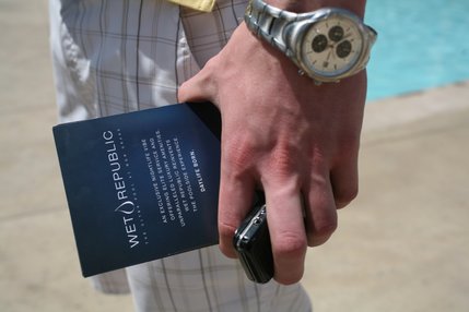 Thomas Kuemmel holds implements of promotion -- a pool party flier and his cell phone -- while the Nightclub Management class throws a pool party at MGM Grand's Wet Republic.