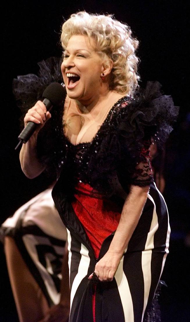 Bette Midler unzips her dress in the middle of a song to reveal another outfit underneath during a performance at the Mandalay Bay Events Center on New Year's Eve Friday, December 31, 1999. 