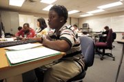 Angel Lee works on an English class book report Wednesday at Desert Rose Adult High School. Lee returned to school after dropping out.