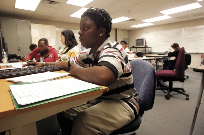 Angel Lee works on an English class book report Wednesday at Desert Rose Adult High School. Lee returned to school after dropping out.