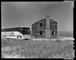 The tour bus passes a two-story building used in the Apple II tests during the monthly public tour of the Nevada Test Site