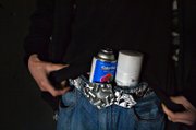 Stashing cans of paint, Ruckoh packs up to walk more than a half mile into a storm drain to paint a mural that will take more than six hours to finish.