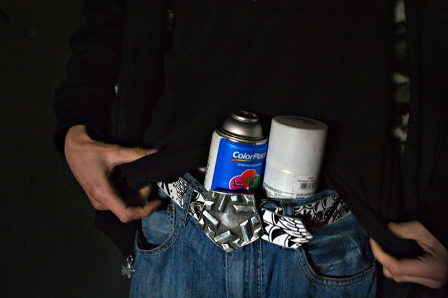 Stashing cans of paint, Ruckoh packs up to walk more than a half mile into a storm drain to paint a mural that will take more than six hours to finish.
