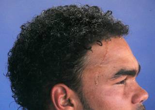 Beads of water from an overhead mister form on Las Vegas 51's pitcher Ramon Troncoso's hair and forehead as he sits in the dugout during a rare day game at Cashman Field. 