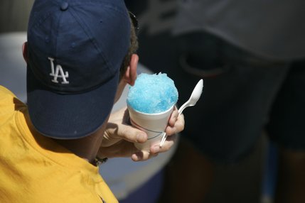 Fan David Zegerman cools off with a cup of blue raspberry shaved ice.