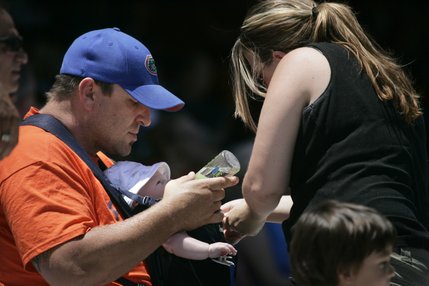 Tyson Redditt gets hydrated by his father Tim Redditt while his mom Andria Redditt applies sunscreen. 