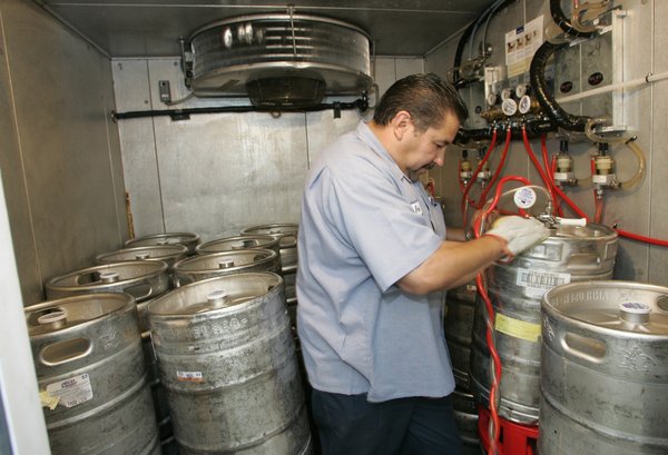 Gabriel Salazar, a Nevada Beverage special events team member, hooks ...