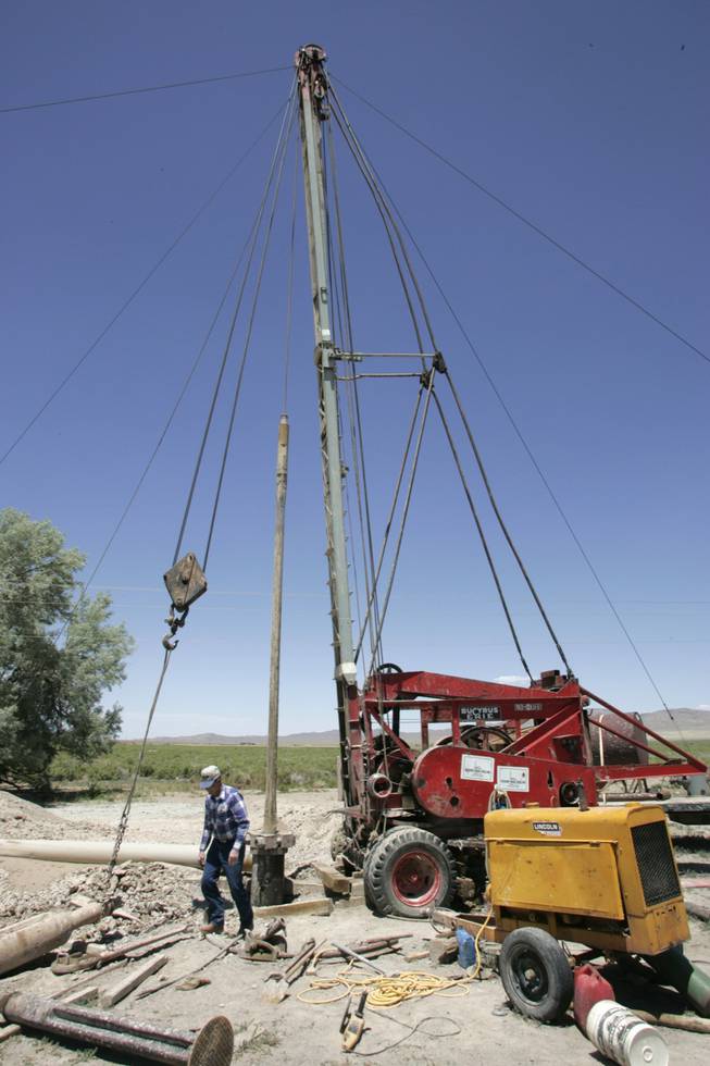Dean Baker checks the progress of work on a drill rig used to bring water to the surface. Baker's 12,000 acres are irrigated by ground water replenished each year by Wheeler Peak's snowmelt. 