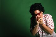 Corvello demonstrates her versatility in playing air instruments, showing off her technique on the air harmonica.