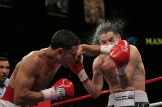 Mario Santiago connects a punch against Steven Luevano during their WBO featherweight title fight. The match ended in a draw, but 