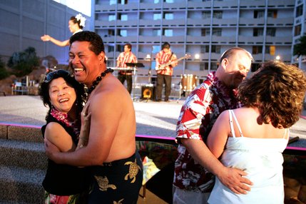 Crowd member Linda Knadle, left, of Pardeeville, Wis. dances with Polynesian dancer Peniamina Lave during the Imperial Luau held poolside at the Imperial Palace's Shangri-la pool. Crowd members with birthdays and anniversaries were called up to the front and had a chance to dance with Polynesian dancers during one part of the show.