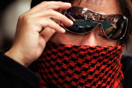 Wally Sombero of Manila, Philippines peeks under his sunglasses to look at his hand during the first day of the  tournament. 