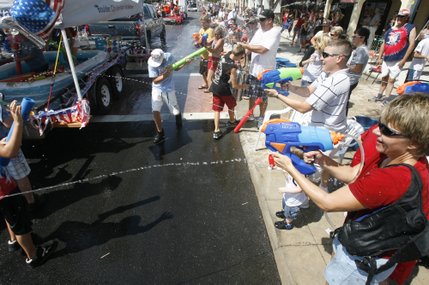 People spray water on each other during the 60th annual Damboree parade parade in Boulder City.