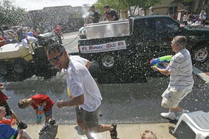 People spray water on each other during the 60th annual Damboree parade in Boulder City.